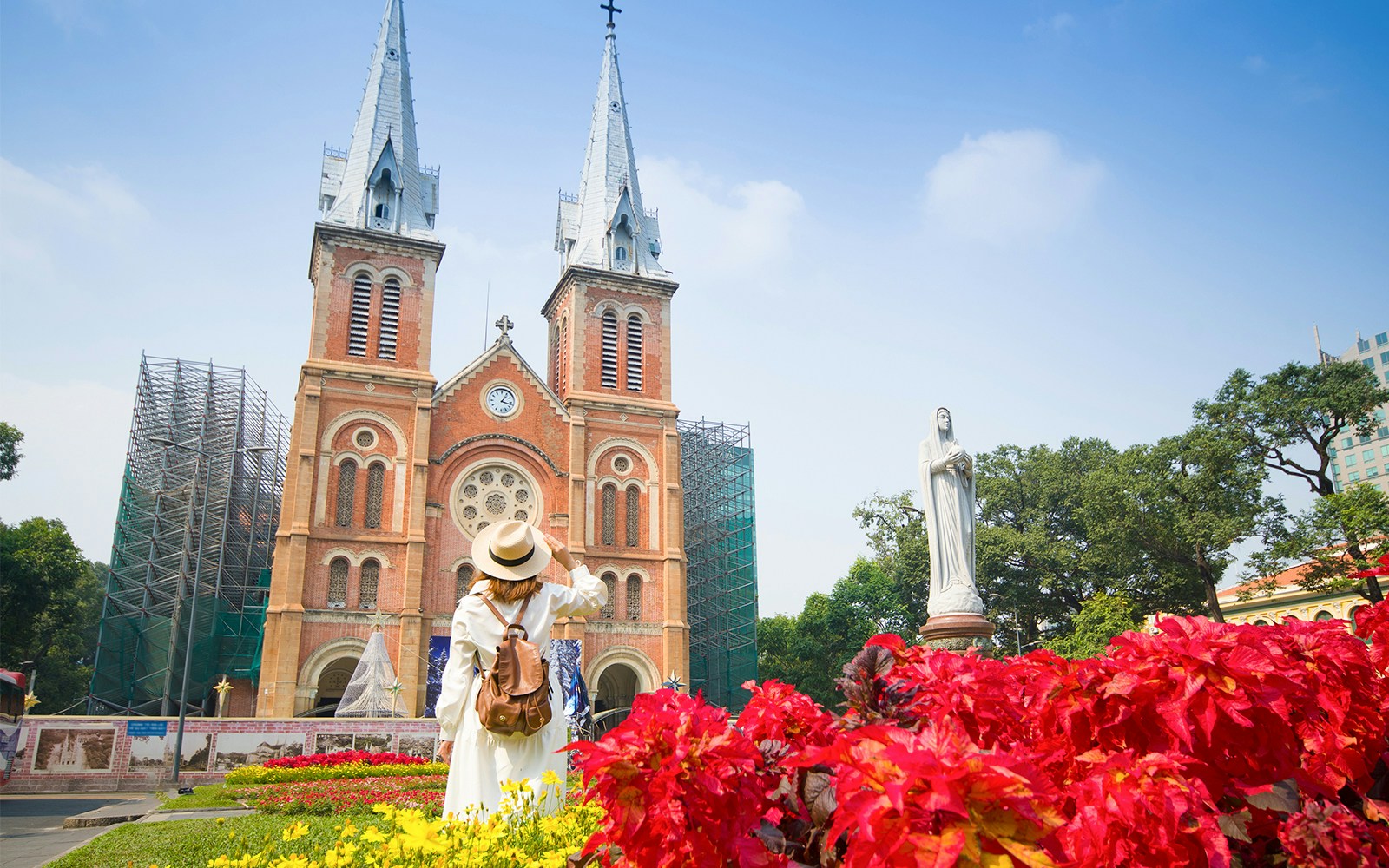Woman tourist is sightseeing in front of Notre Dame Cathedral of Saigon in Hochiminh City in Vietnam.