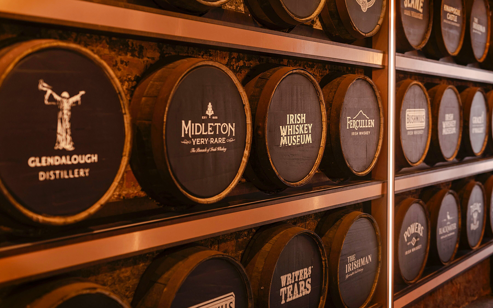 Barrels at the Irish Whiskey Museum featuring various distillery names.