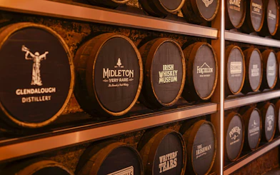Barrels at the Irish Whiskey Museum featuring various distillery names.