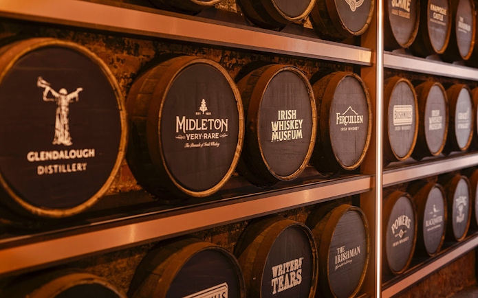 Barrels at the Irish Whiskey Museum featuring various distillery names.