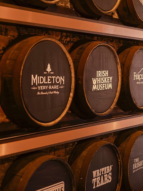 Barrels at the Irish Whiskey Museum featuring various distillery names.