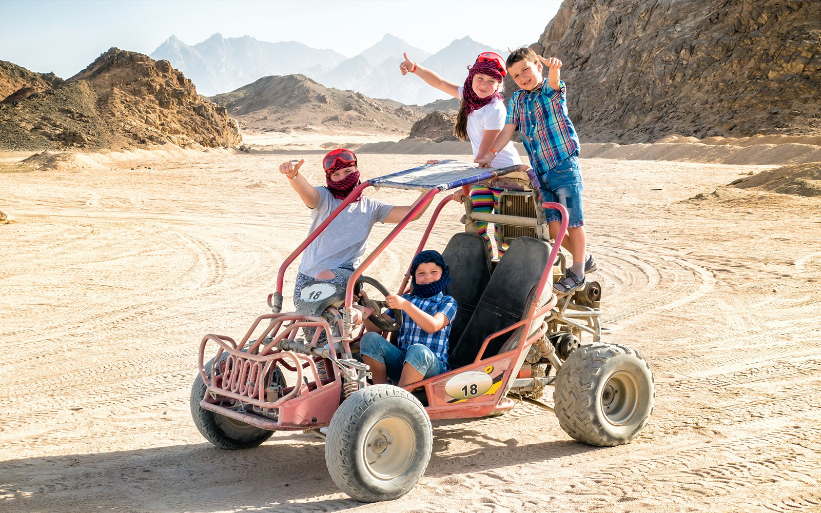 Family on ATV in Hurghada desert during Super Safari tour.