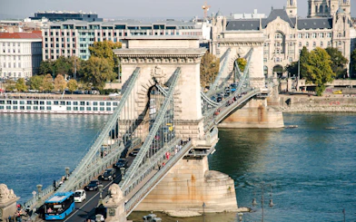 Széchenyi Chain Bridge spanning the Danube River in Budapest, Hungary, with traffic and pedestrians.