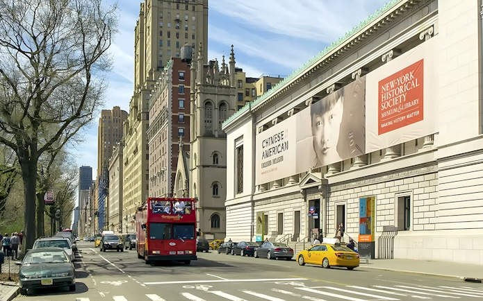 New York Historical Society building exterior with street view and tour bus.