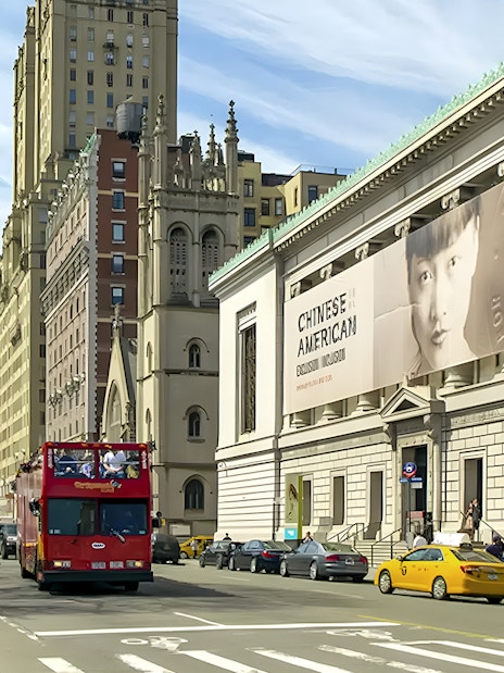 New York Historical Society building exterior with street view and tour bus.