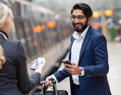 Passengers with luggage boarding the Heathrow Express at Heathrow Airport.