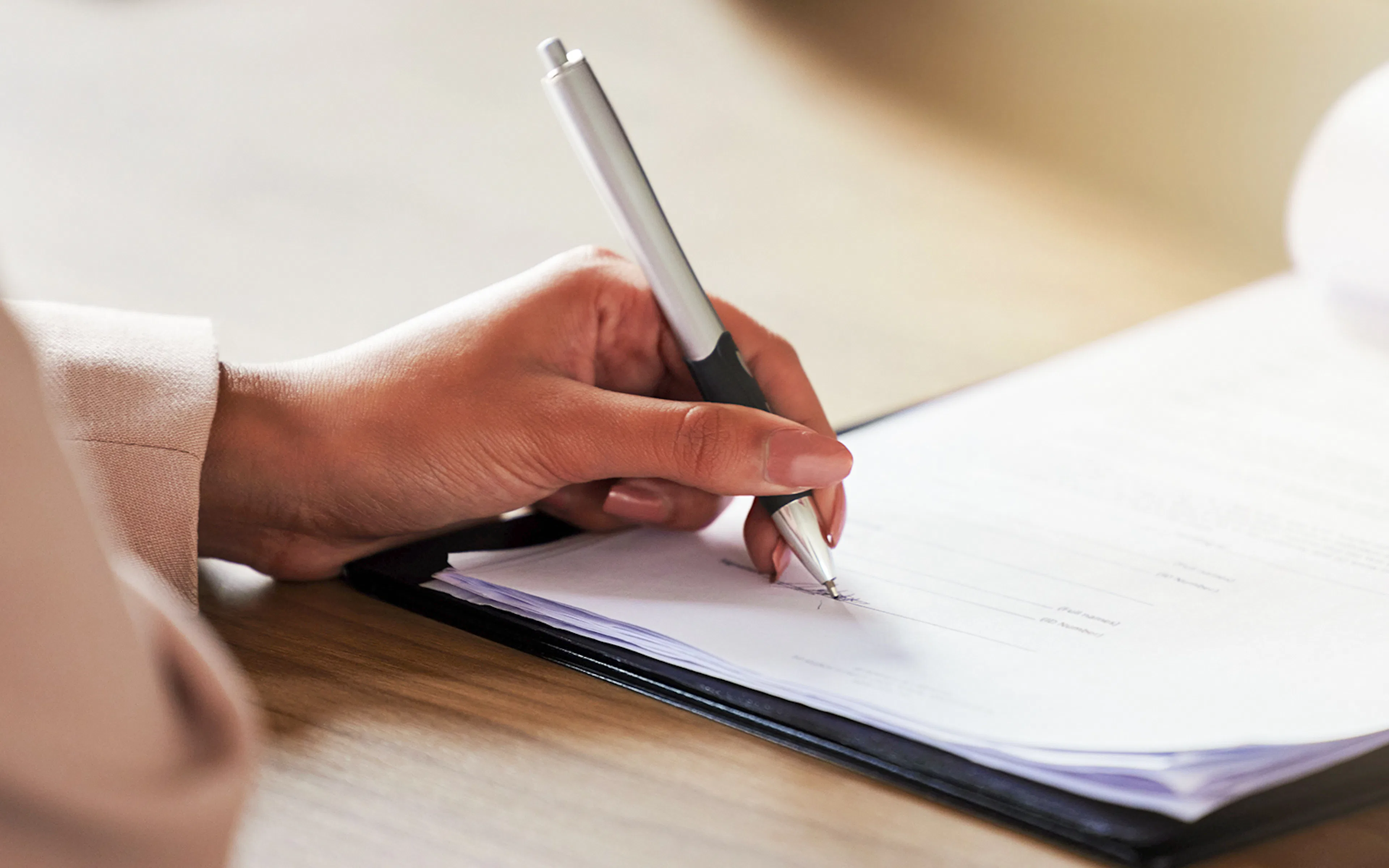 Hand signing a waiver document with a pen.