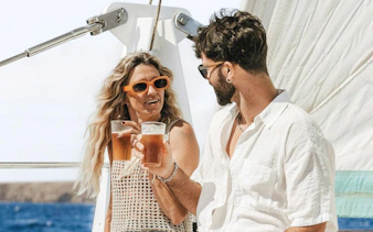 Couple enjoying drinks on a sailboat during a mini cruise to Papagayo Beaches, Lanzarote.