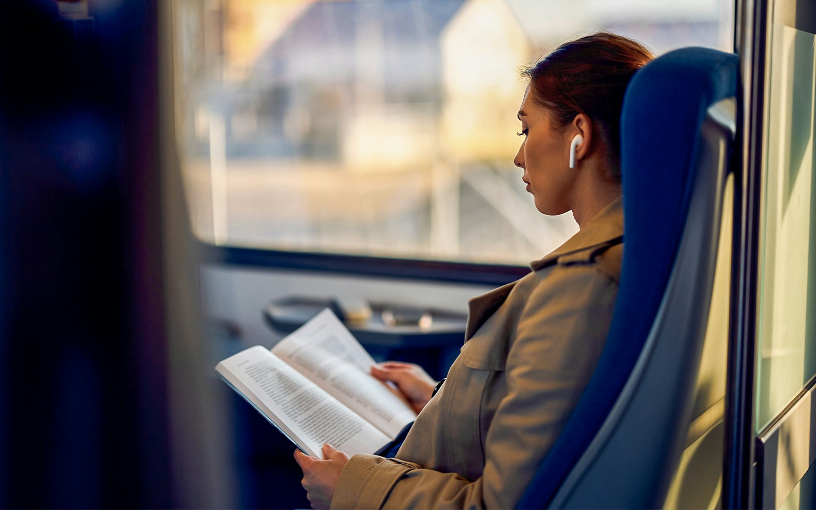 Train passenger reading a book on the Madrid Atocha to Barcelona route.