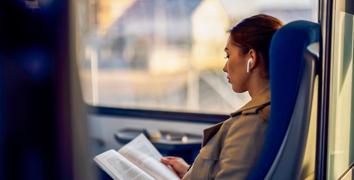 Train passenger reading a book on the Madrid Atocha to Barcelona route.