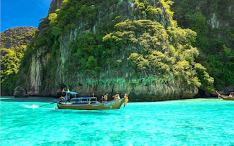 Speedboat near lush cliffs on Phi Phi Islands, Phuket tour.