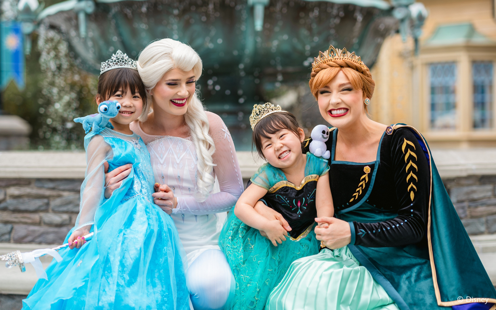 Girls dressed as Anna and Elsa with characters at Frozen Ever After, Disneyland Hong Kong.