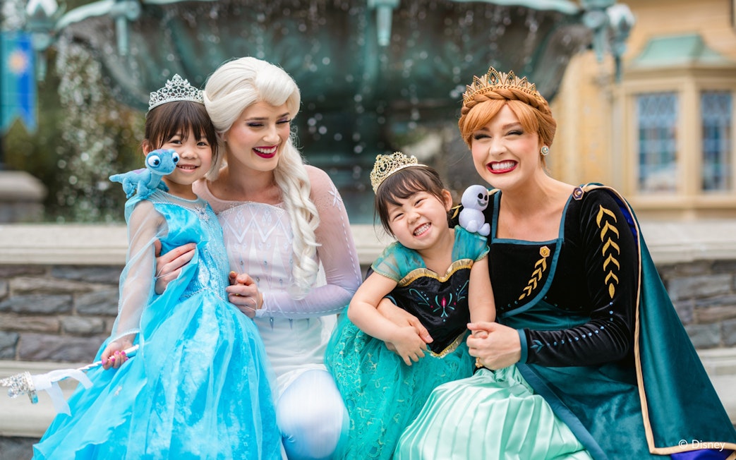 Girls dressed as Anna and Elsa with characters at Frozen Ever After, Disneyland Hong Kong.