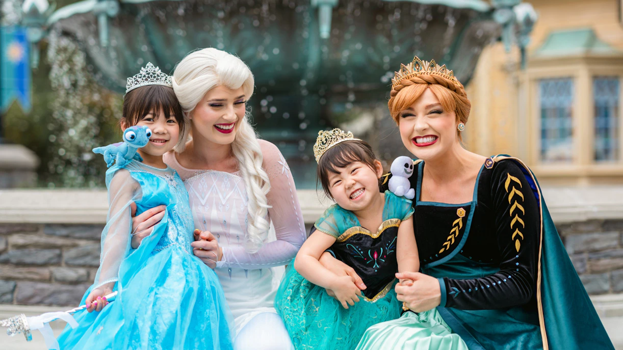 Girls dressed as Anna and Elsa with characters at Frozen Ever After, Disneyland Hong Kong.