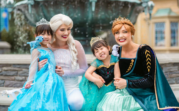 Girls dressed as Anna and Elsa with characters at Frozen Ever After, Disneyland Hong Kong.