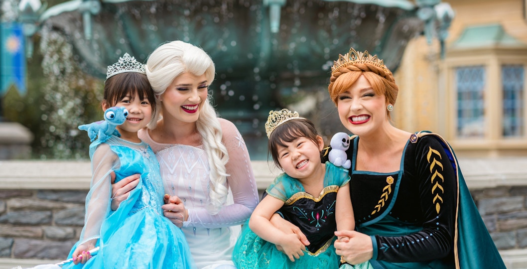 Girls dressed as Anna and Elsa with characters at Frozen Ever After, Disneyland Hong Kong.