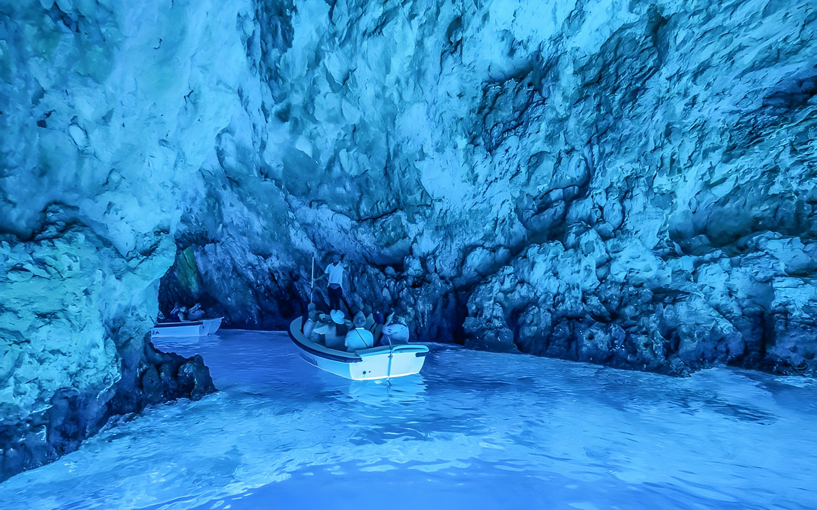 Visitors in a small boat explore the Blue Cave near Split.