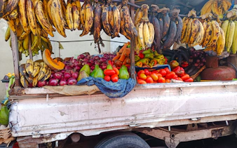 Fresh produce stall with bananas, onions, avocados, and peppers at Mercado Modelo, Santo Domingo.
