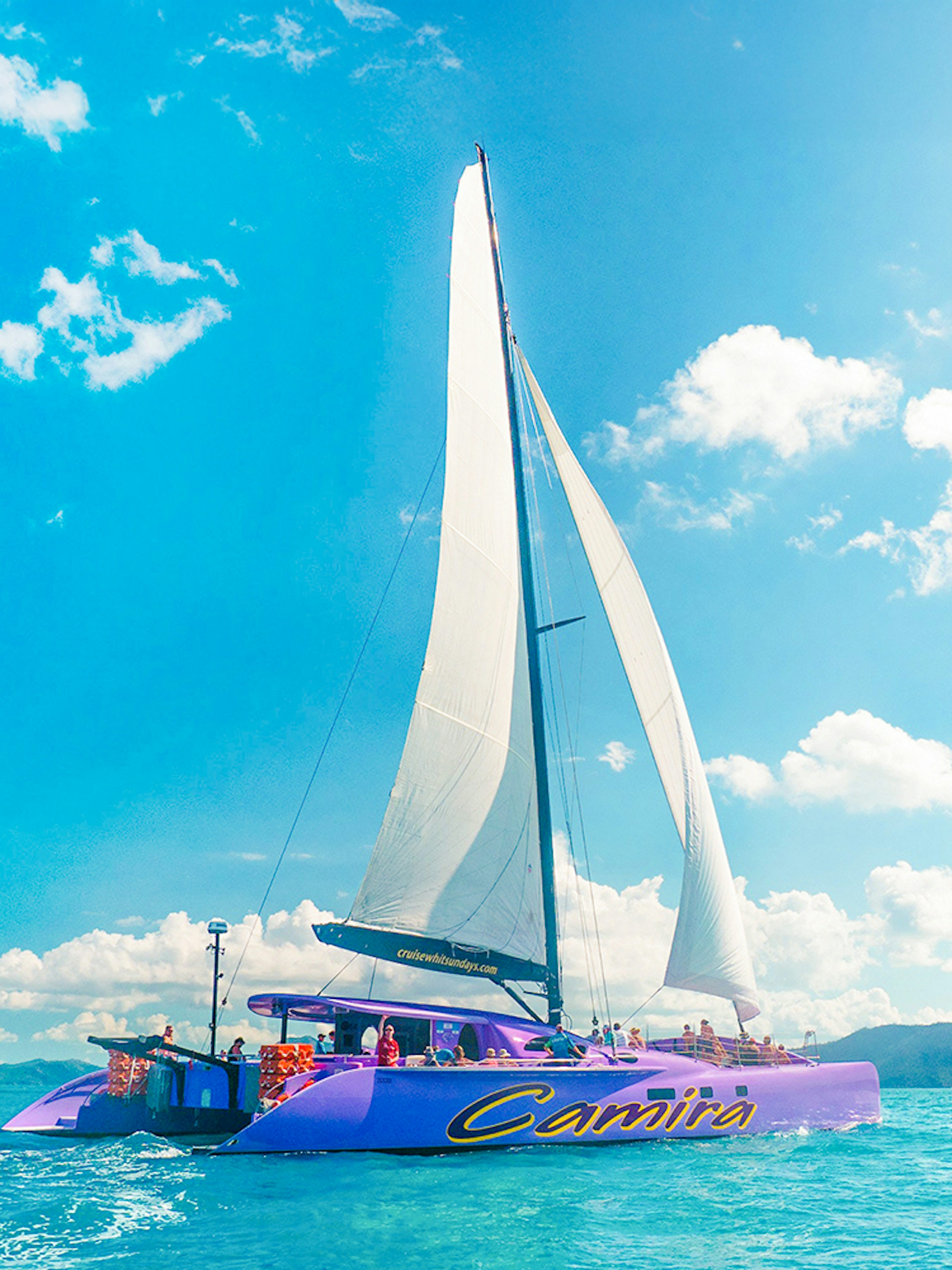 Sailing catamaran on clear waters during Airlie Beach Camira adventure.