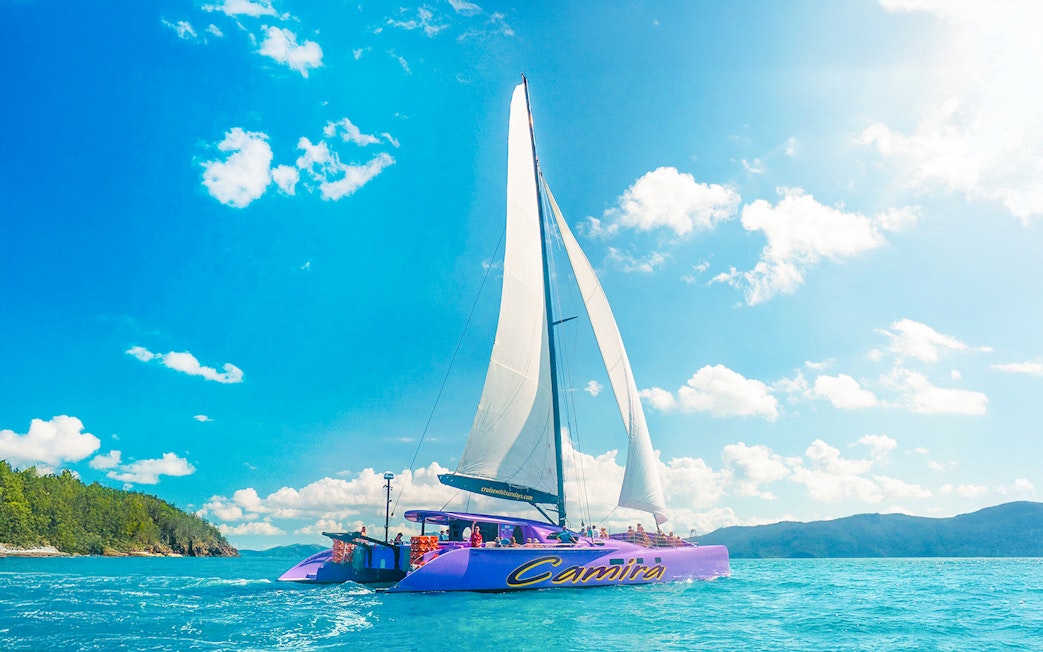 Sailing catamaran on clear waters during Airlie Beach Camira adventure.