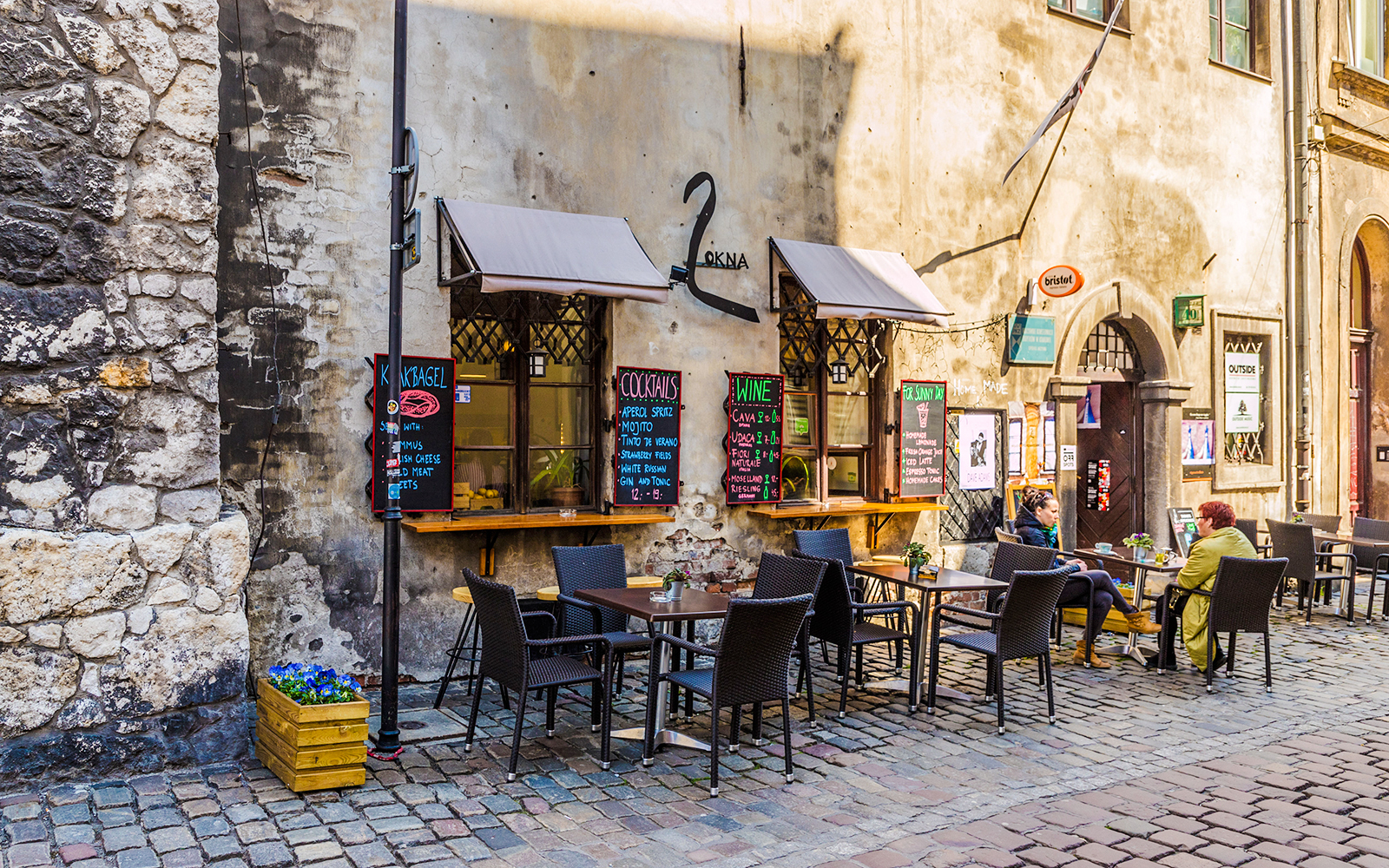 Outdoor café in Jewish Quarter Kazimierz, Krakow with patrons seated at tables.