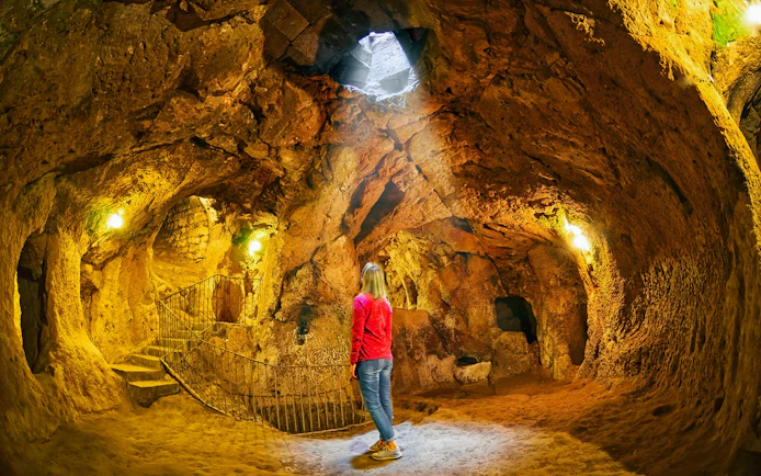 Visitor exploring Derinkuyu underground city in Cappadocia, Turkey.