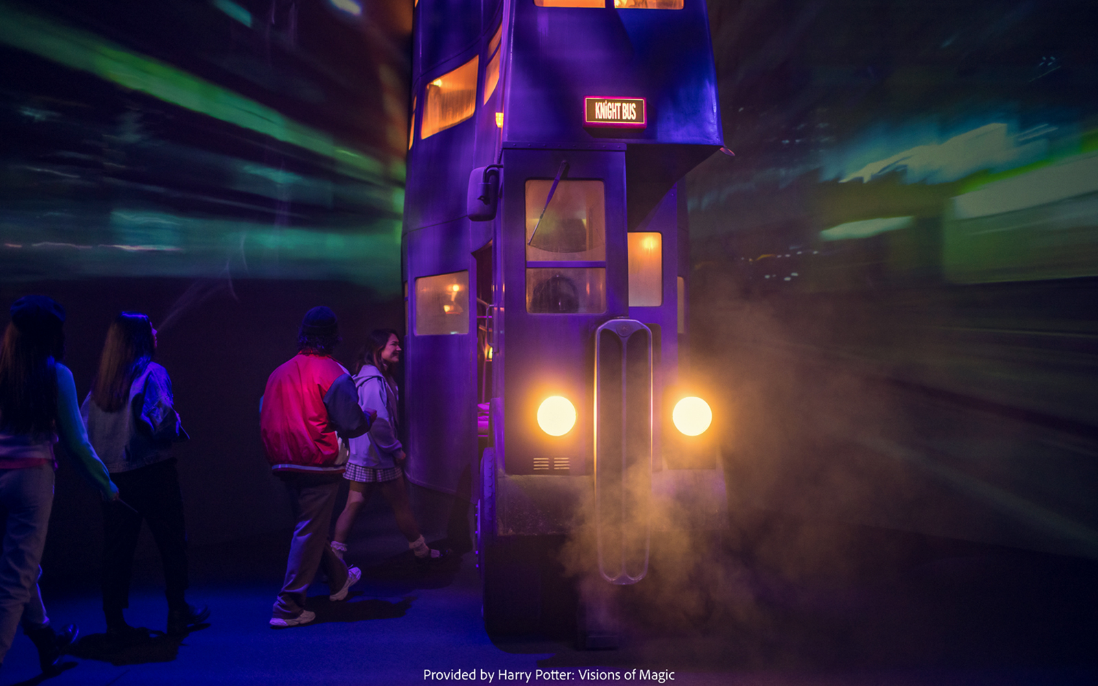 Visitors boarding the Knight Bus at Harry Potter: Visions of Magic exhibit.