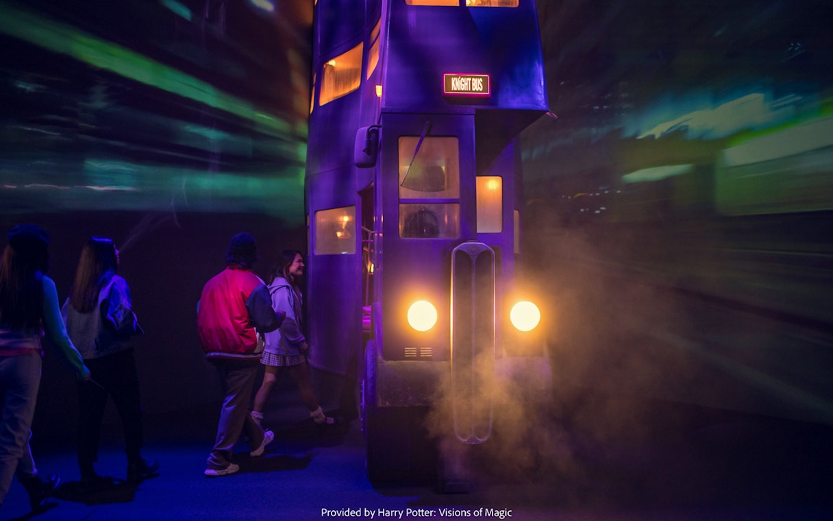 Visitors boarding the Knight Bus at Harry Potter: Visions of Magic exhibit.