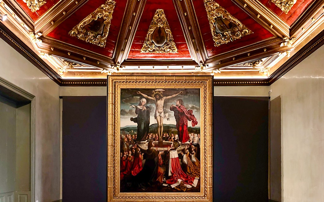 Crucifixion painting in Misericórdia Museum, Porto, with ornate ceiling detail.