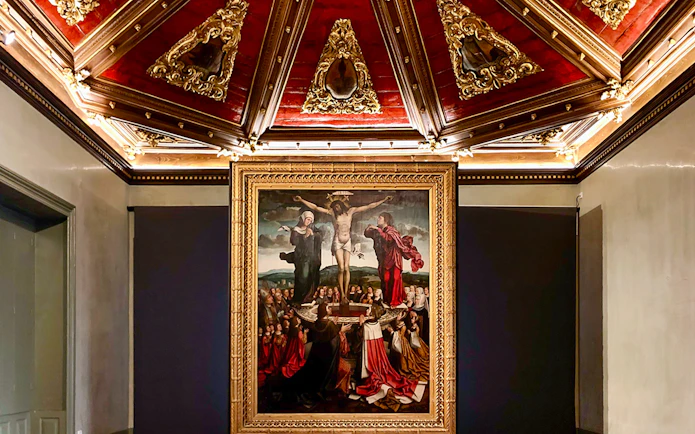 Crucifixion painting in Misericórdia Museum, Porto, with ornate ceiling detail.