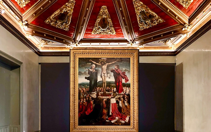 Crucifixion painting in Misericórdia Museum, Porto, with ornate ceiling detail.