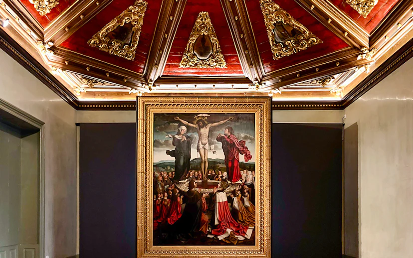 Crucifixion painting in Misericórdia Museum, Porto, with ornate ceiling detail.