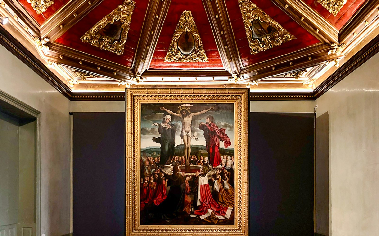 Crucifixion painting in Misericórdia Museum, Porto, with ornate ceiling detail.