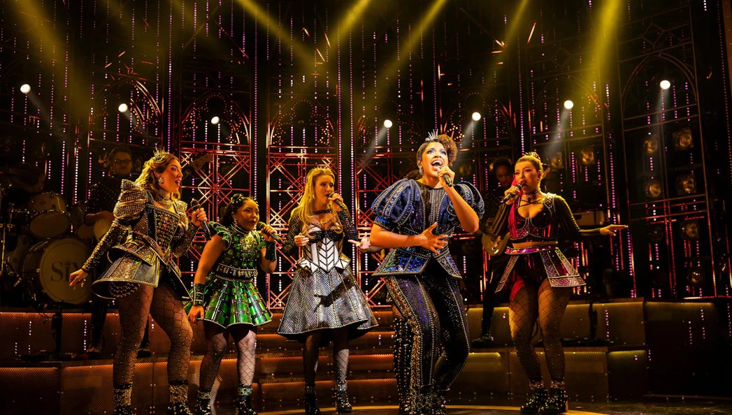 Performers singing on stage during Six musical in West End.