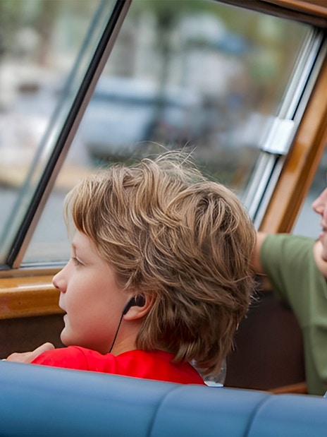 Passengers using audio guides on a canal cruise.