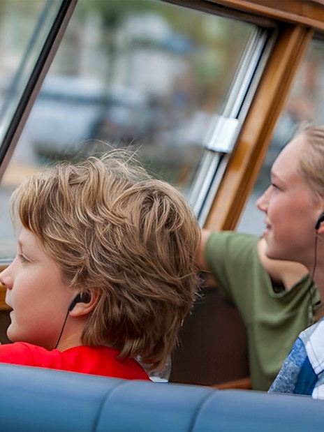 Passengers using audio guides on a canal cruise.