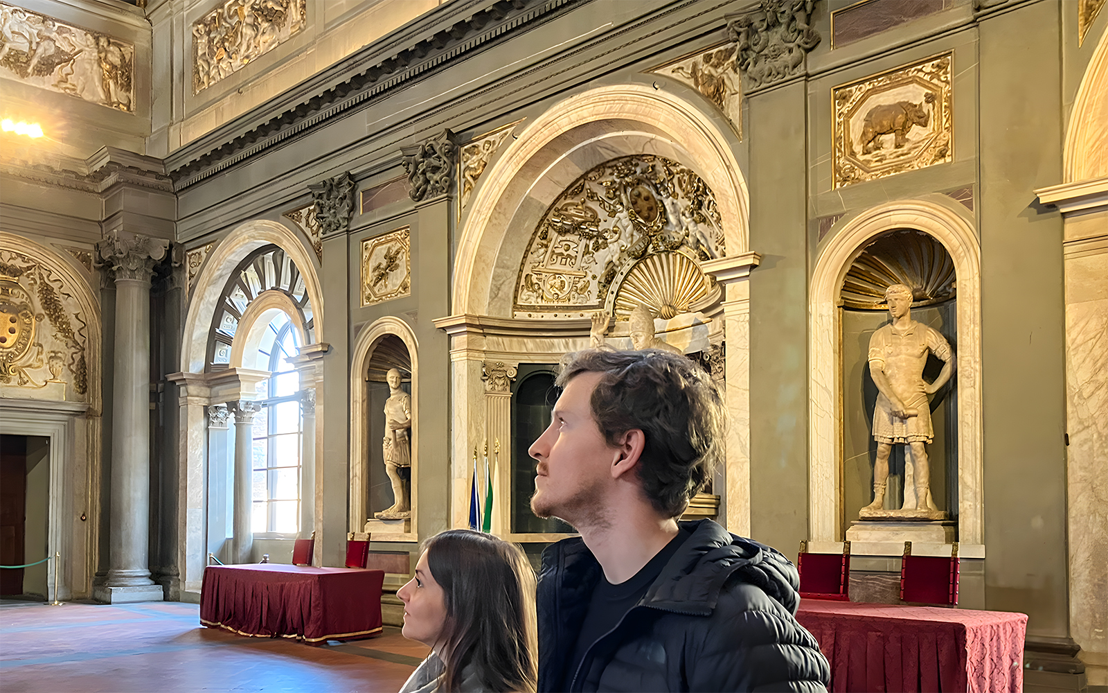 Tourists exploring the ornate interiors of Palazzo Vecchio in Florence, Italy.