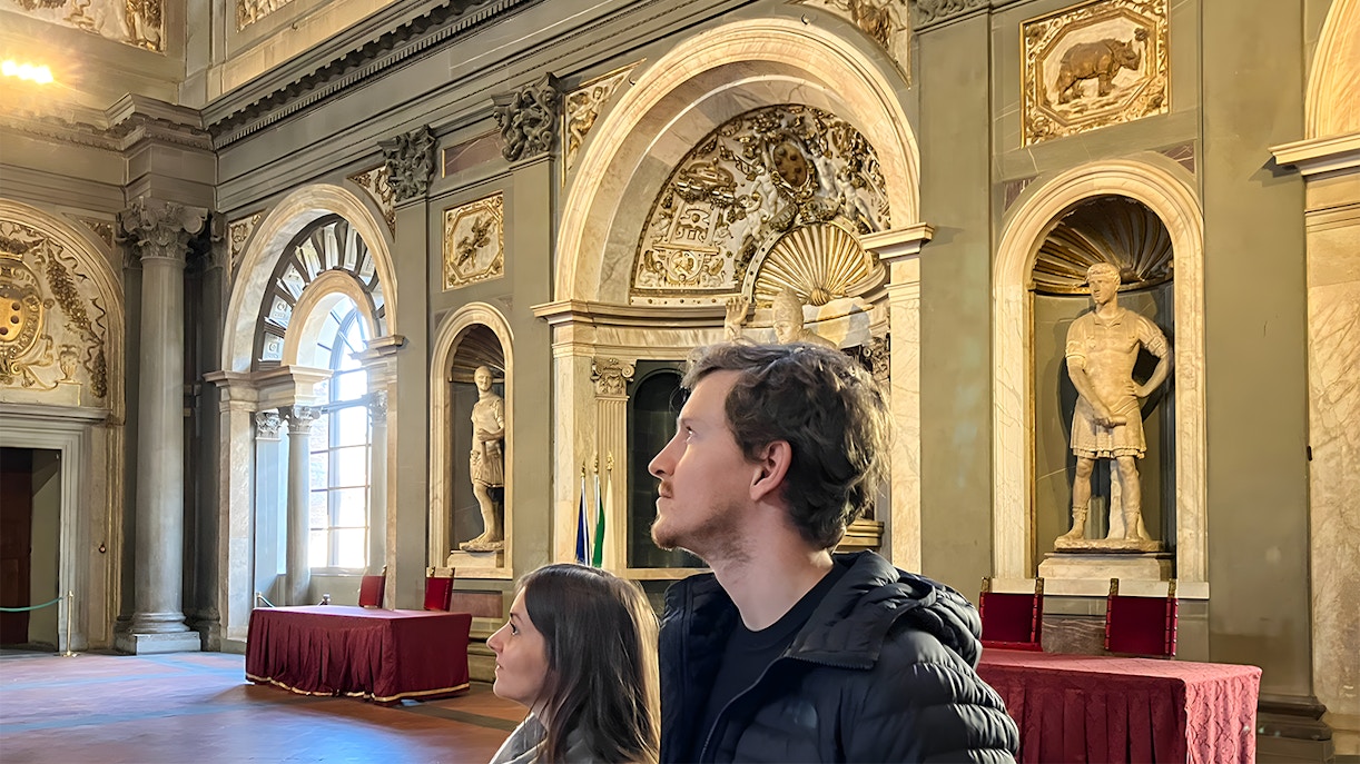 Tourists exploring the ornate interiors of Palazzo Vecchio in Florence, Italy.