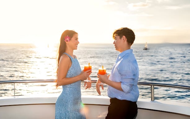 Couple enjoying Mai Tai on a sunset cruise in Waikiki, Hawaii.