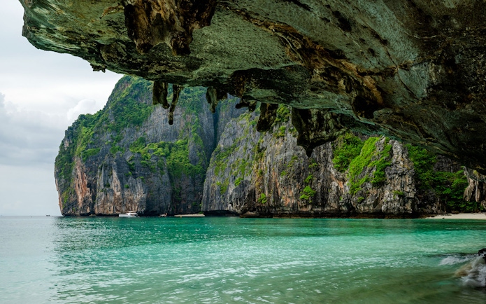 View from a sea cave of Maya Bay's limestone cliffs and clear water, Phi Phi Island.
