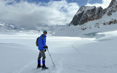 Trekker on snowy Ojo del Albino Glacier with mountain backdrop in Argentina.