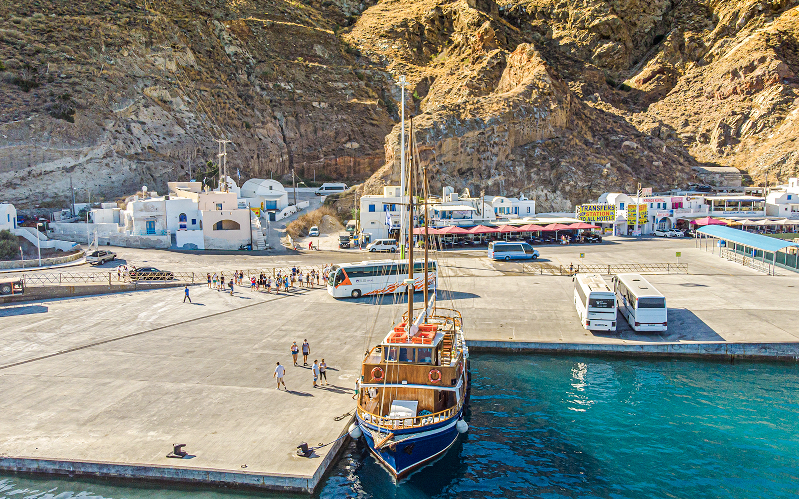 Bus and boat at Santorini port for tourist transfers.