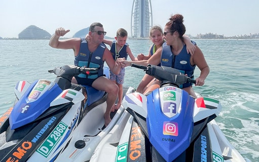 Family on jet skis near Burj Al Arab, Dubai.