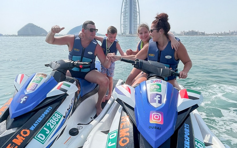 Family on jet skis near Burj Al Arab, Dubai.