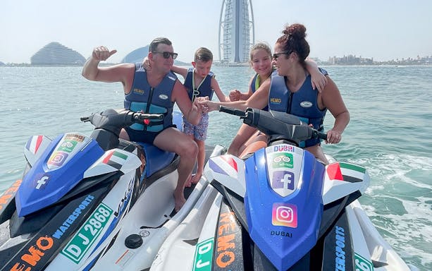 Family on jet skis near Burj Al Arab, Dubai.