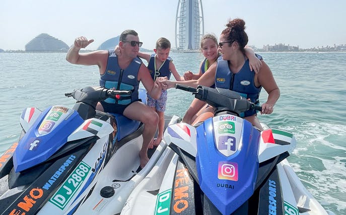 Family on jet skis near Burj Al Arab, Dubai.