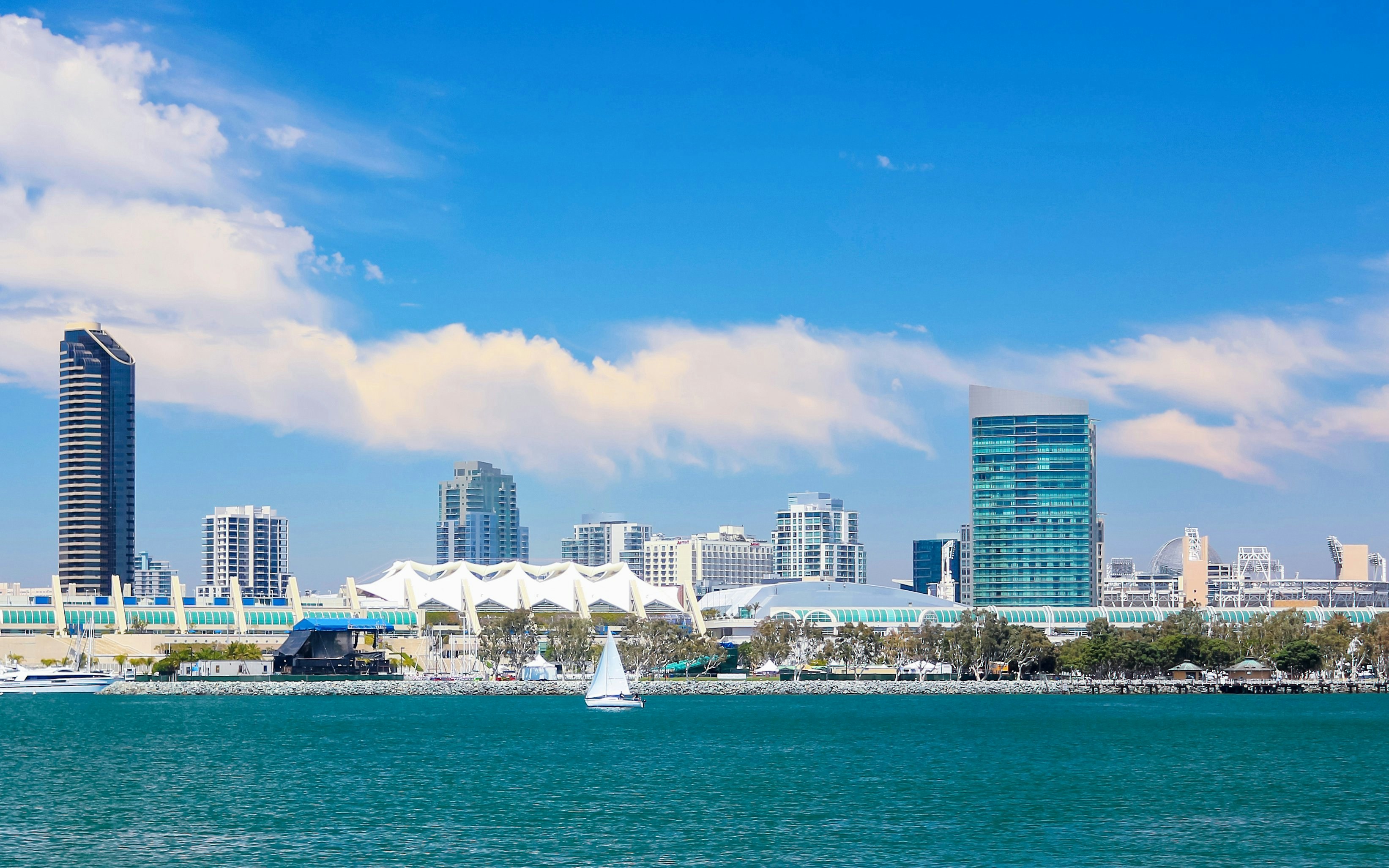 San Diego Bay with skyline and sailboat in foreground.