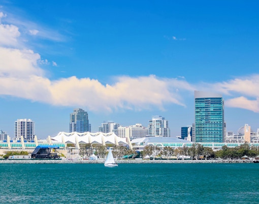 San Diego Bay with skyline and sailboat in foreground.