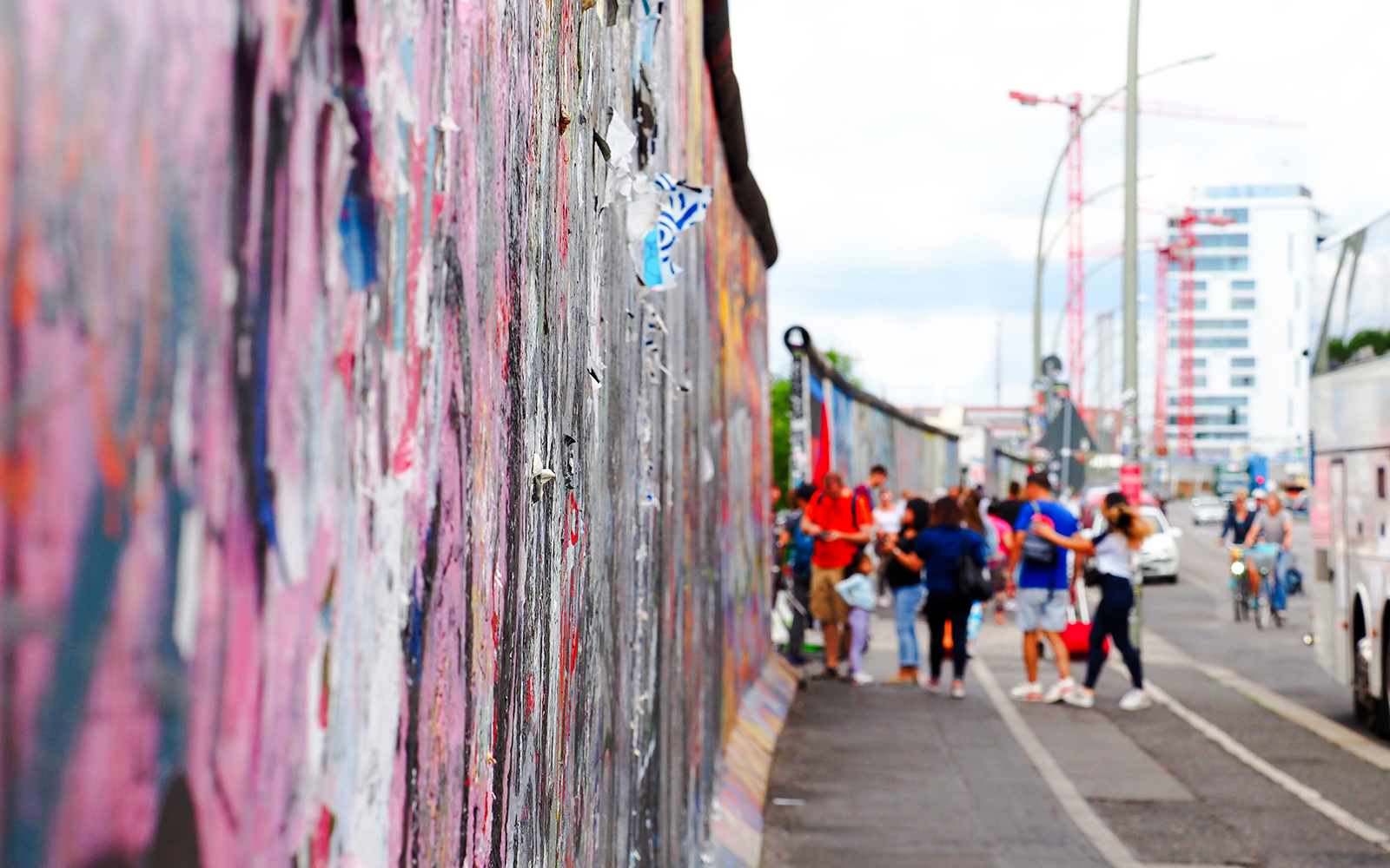 Tourists walking along the graffiti-covered Berlin Wall in Berlin.