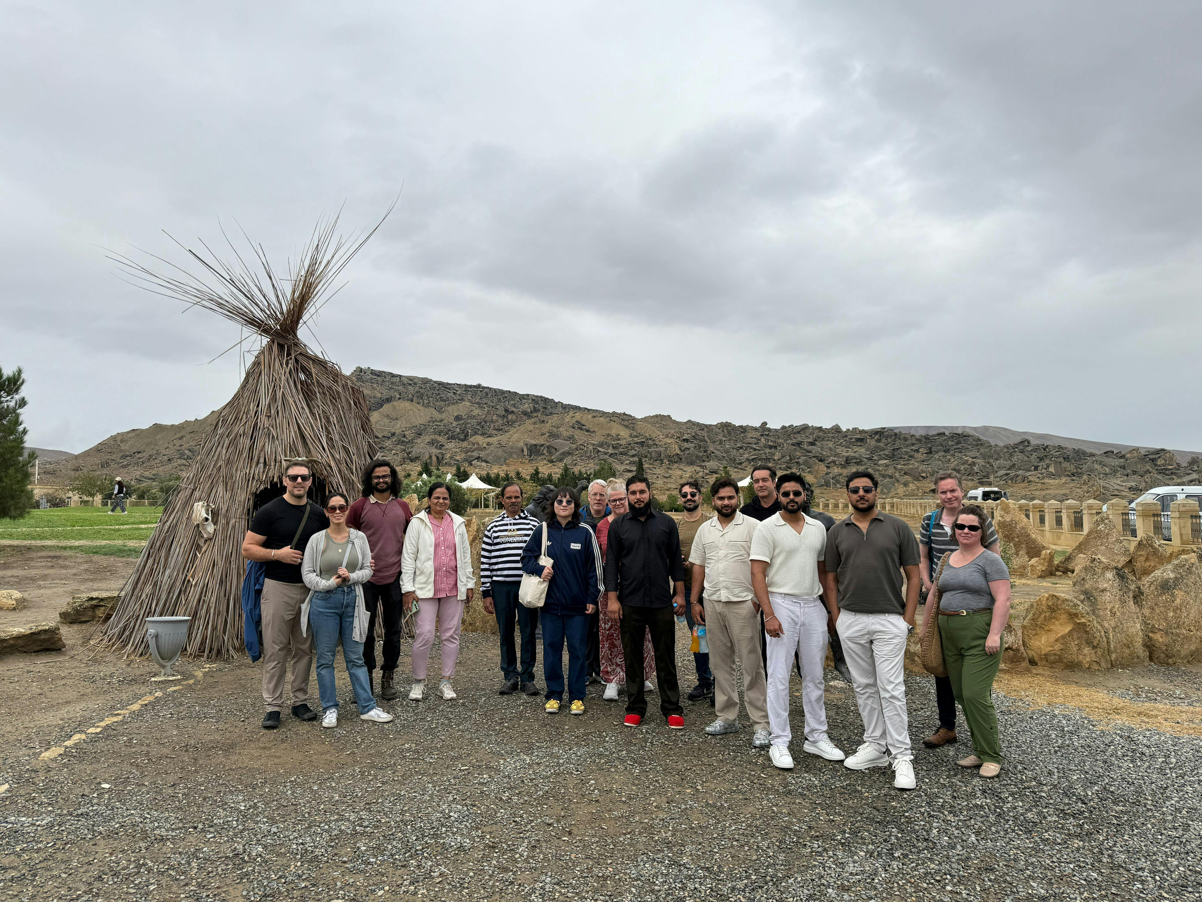 Group of tourists at Gobustan National Park with mud volcanoes in the background.